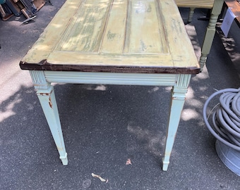 Mesa auxiliar de la década de 1880, hecha con una puerta y con tablero de cristal. Medidas: 42 x 29 3/4 pulgadas. Patas recicladas.