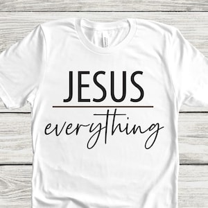 May include: White t-shirt with black text that reads "JESUS everything" with a small cross above the word "everything".