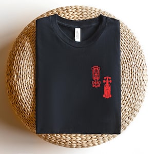 Peut inclure: T-shirt noir avec un contour rouge de deux voitures de course sur le devant.