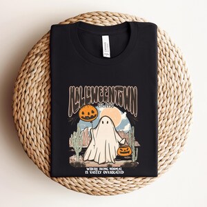 May include: Black t-shirt with a graphic of a ghost holding a jack-o-lantern. The graphic says "Halloweentown Est. 1998" and "Where being normal is vastly overrated".