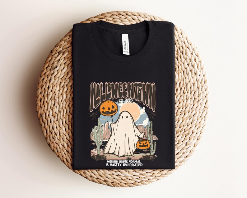 May include: Black t-shirt with a graphic of a ghost holding a jack-o-lantern. The graphic says "Halloweentown Est. 1998" and "Where being normal is vastly overrated".