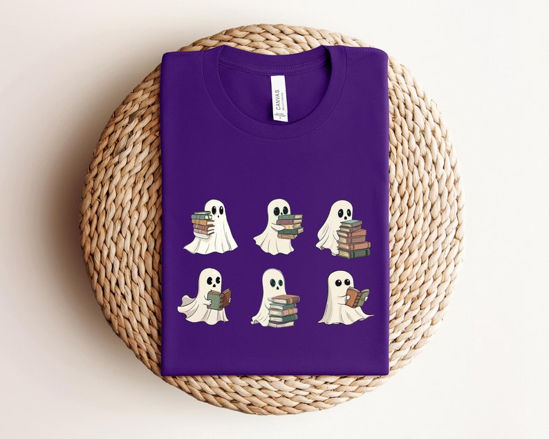 Może przedstawiać: Fioletowy T-shirt z wzorem sześciu białych duch&oacute;w trzymających lub czytających książki. Duchy mają czarne oczy i są w r&oacute;żnych pozach.