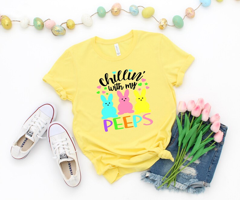 May include: Yellow t-shirt with the text "Chillin' with my peeps" and three colorful marshmallow peeps.