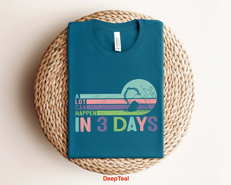 Puede incluir: Una camiseta azul turquesa con un gr&aacute;fico de estilo retro que dice "Mucho puede pasar en 3 d&iacute;as". El gr&aacute;fico presenta un dise&ntilde;o a rayas de colores con una silueta de una persona buceando en el agua.