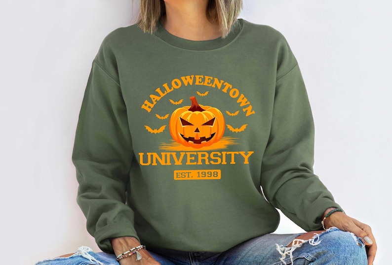 May include: Green sweatshirt with an orange pumpkin and the text "Halloweentown University Est. 1998"