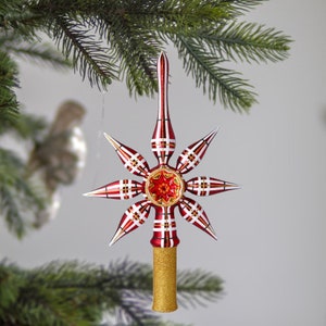 May include: Red and white plaid glass star Christmas tree topper with a gold base.