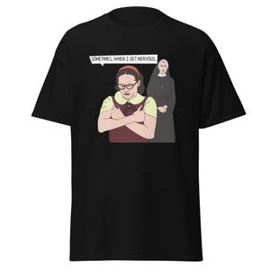 May include: Black t-shirt featuring a cartoon illustration of a woman wearing glasses and a nun. The text "Sometimes, when I get nervous." is in a speech bubble above the woman.