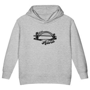 May include: A light heather gray hooded sweatshirt featuring a black graphic print on the chest. The design depicts the Hell Gate Bridge with the text Hell Gate above the arch and the word Astoria in a cursive script font positioned below.