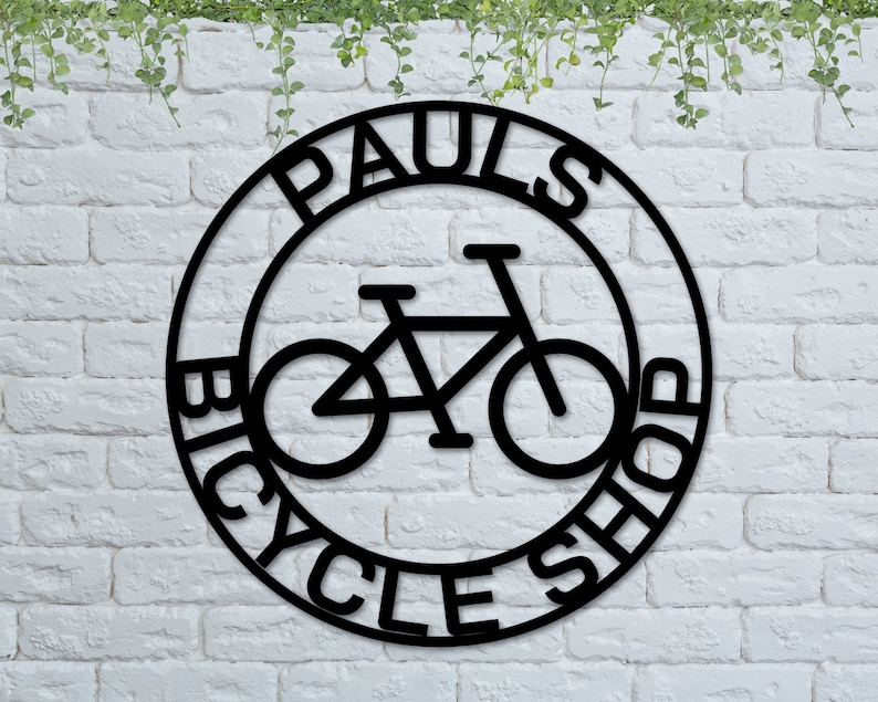 May include: Black metal sign with the words "Paul's Bicycle Shop" in a circle around a silhouette of a bicycle.