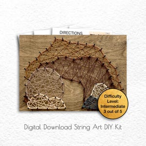 May include: A digital download string art DIY kit featuring a mountain range design. The design is made with brown, tan, and gray string on a wood background. The difficulty level is listed as intermediate, 3 out of 5.