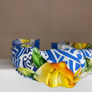 May include: A blue and white headband with a knotted design and a lemon print.
