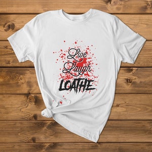 May include: White t-shirt with red splatter paint and the text "Live Laugh Loathe" in black.