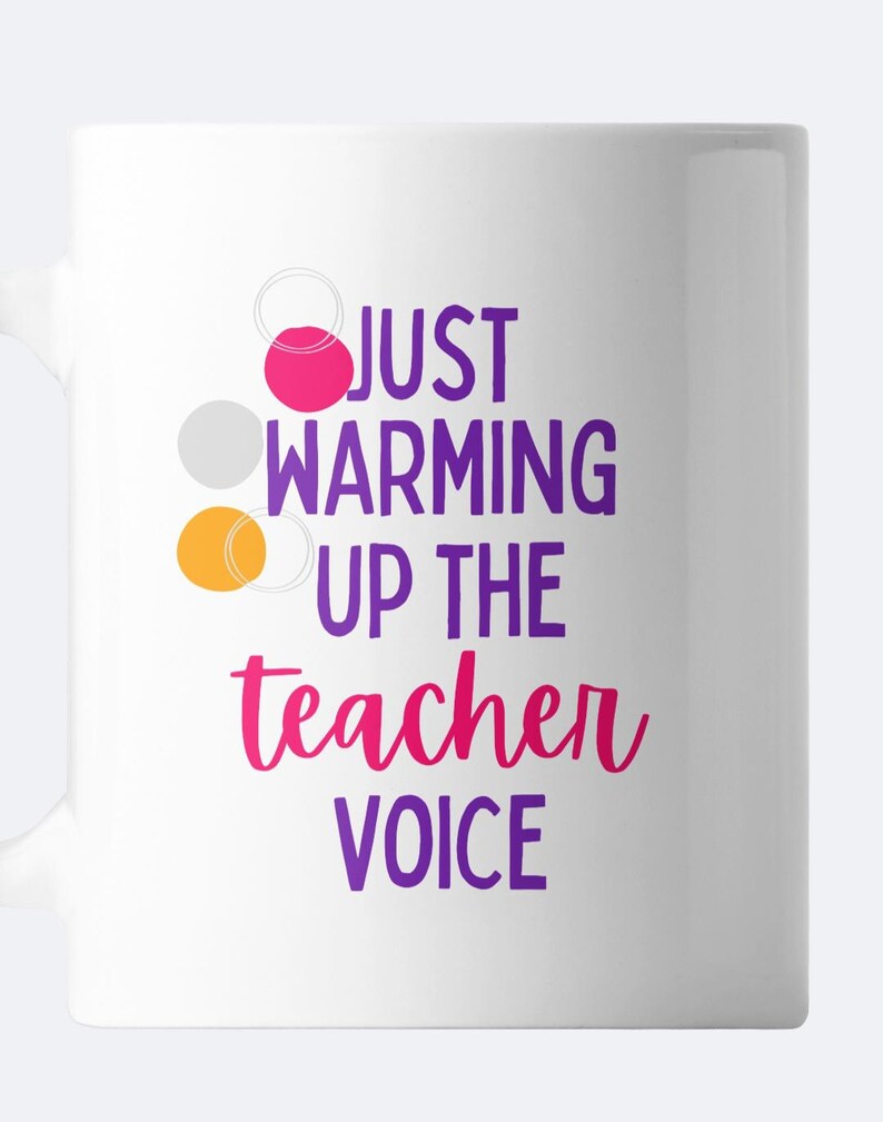 May include: White ceramic mug with a purple, pink, and orange design. The mug reads "Just warming up the teacher voice".