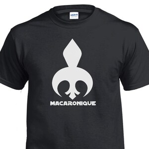 May include: Black t-shirt featuring a white graphic of a stylised fleur-de-lis with the word "MACARONIQUE" underneath.