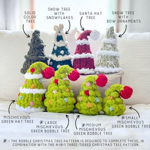 May include: A collection of handmade Christmas tree decorations. The trees are in various styles, including a solid color tree, a snow tree with snowflakes, a Santa hat tree, and a snow tree with bow ornaments. The mischievous green bobble trees are also featured. The text on the image reads: "The bobble Christmas tree pattern is required to complete these, in combination with the 4-in-1 three-tiered Christmas tree pattern."