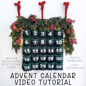 May include: A handmade green Advent calendar with white numbers 1-25 in individual pockets. The calendar is decorated with greenery, red berries, and two red hanging loops. Text on the image reads "Advent Calendar Video Tutorial".