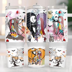 K&ouml;nnte beinhalten: Drei wei&szlig;e isolierte Becher mit Griffen, jeder mit einer anderen Illustration aus "The Nightmare Before Christmas". Die Designs umfassen Jack Skellington, Sally und andere Charaktere, mit Flederm&auml;usen, Rosen und Spinnweben. Die Becher haben einen wei&szlig;en Boden und einen silbernen Deckel.