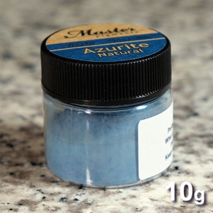 K&ouml;nnte beinhalten: Ein kleines Glasgef&auml;&szlig; mit schwarzem Deckel, gef&uuml;llt mit blauem Pulver. Das Etikett auf dem Gef&auml;&szlig; lautet "Master Pigments" und "Azurite Natural". Das Gef&auml;&szlig; enth&auml;lt 10 Gramm Pulver.