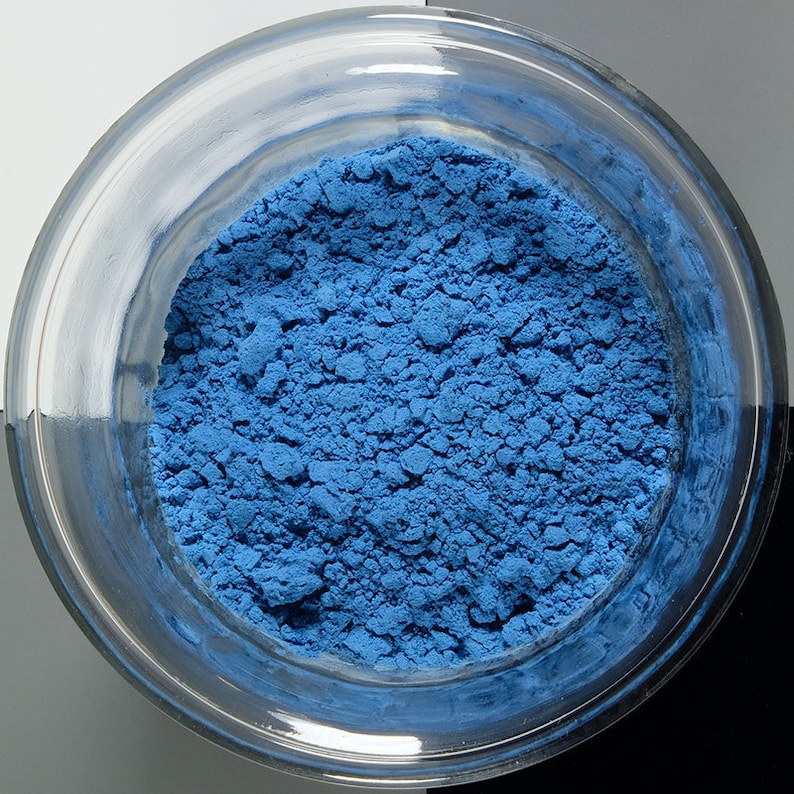 K&ouml;nnte beinhalten: Eine kleine Glassch&uuml;ssel gef&uuml;llt mit einem leuchtend blauen Pulver. Das Pulver ist fein gemahlen und hat eine leicht k&ouml;rnige Textur.