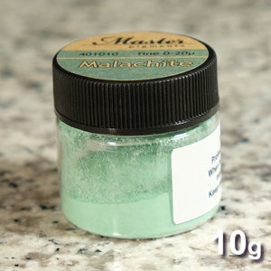 May include: A small glass jar with a black lid containing a green powder. The label on the jar reads "Master pigments fine 0-20&micro; Malachite 401010 10g".