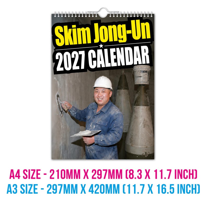 Pu&ograve; includere: Calendario da parete con rilegatura a spirale in alto. Il calendario presenta il testo "Skim Jong-Un 2027 CALENDAR" in giallo e bianco. L'immagine mostra un uomo con elmetto bianco e abiti da lavoro blu. I formati sono A4 (210mm x 297mm) e A3 (297mm x 420mm).