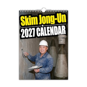 Pu&ograve; includere: Un calendario da parete con rilegatura a spirale e la scritta "Skim Jong-Un 2027 CALENDAR" in giallo e bianco. L'immagine mostra un uomo in tuta blu da lavoro e casco bianco, che applica intonaco a un muro. Due grandi oggetti cilindrici sono sullo sfondo.