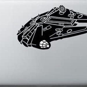 Può includere: Una grafica in bianco e nero dell'astronave Millennium Falcon è visualizzata su un laptop argentato. Il design dell'astronave è intricato, con numerosi pannelli, linee e forme. Il laptop è chiuso, con l'immagine sul coperchio.