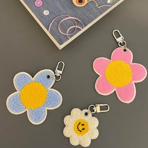 Väskberlock, Blomma, Leendeansikteberlock, Daisyberlock, Väsktillbehör, Tygmärke, Handväskberlock, Dragkedja, Blomnyckelring, Leendenyckelring,