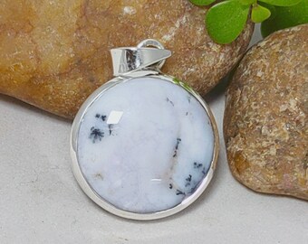 May include: A round pendant with a white and black dendritic agate stone set in a silver bezel.