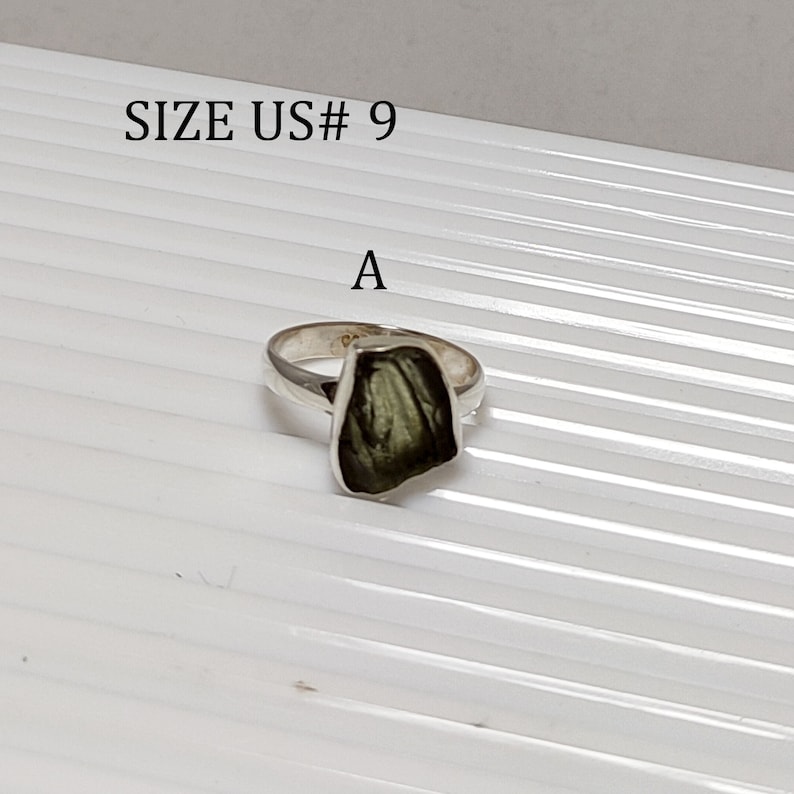 Pu&ograve; includere: Un anello d'argento con una pietra verde scuro. L'anello &egrave; taglia US# 9. La pietra ha una forma irregolare e grezza.