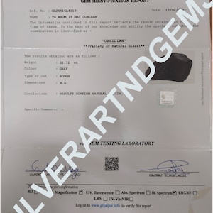 May include: A GTL Gem Identification Report for a 32.72 ct rough grey obsidian specimen. The document includes the GJEPC India logo, reference number GL2461CA4113, dated 15/04/2021, and features two signatures at the bottom with a QR code.