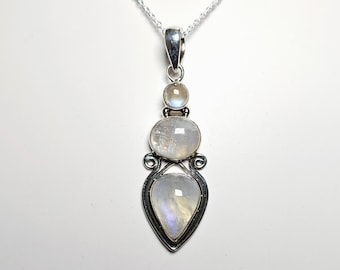 May include: A silver pendant necklace featuring three iridescent moonstone gemstones. The pendant has a teardrop-shaped bottom stone, an oval middle stone, and a round top stone. The stones are set in a decorative silver frame.