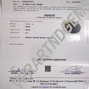 Pu&ograve; includere: Un rapporto di identificazione di gemma per una Moldavite verde, del peso di 59,95 carati, con taglio grezzo. Il rapporto afferma che la gemma &egrave; naturale e ne conferma l'origine. Il rapporto &egrave; datato 03/06/202 e include il nome "GTL" per Gem Testing Laboratory.