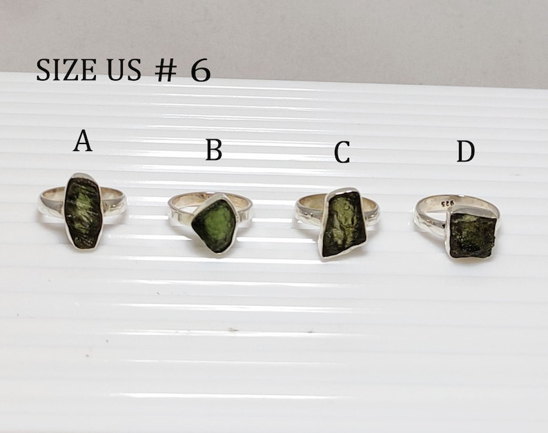 Pu&ograve; includere: Quattro anelli d'argento con diverse pietre preziose verdi. Gli anelli sono etichettati con A, B, C e D. Il testo "SIZE US # 6" &egrave; nella parte superiore dell'immagine.
