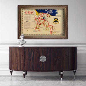 Puede incluir: Un mapa vintage de la invasi&oacute;n del D&iacute;a D en Normand&iacute;a, Francia, con l&iacute;neas rojas que muestran el avance de los aliados. El mapa est&aacute; enmarcado en oro y se exhibe en un gabinete de madera oscura.