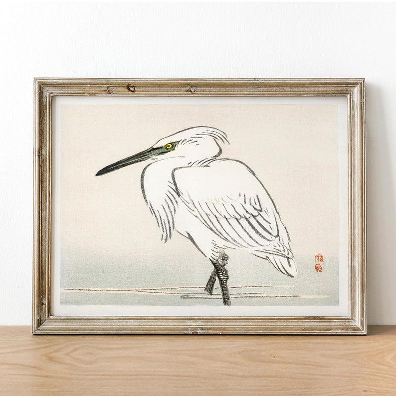 May include: A vintage Japanese woodblock print of a white egret standing on a branch. The bird is depicted in a traditional style with delicate lines and shading. The print is framed in a simple wooden frame.