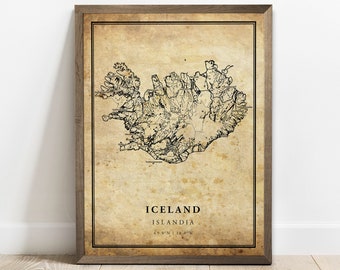 May include: A vintage-style map print of Iceland, featuring a black and white outline of the country's shape and coastline. The map is set against a beige background with a distressed, aged look. The text "Iceland" and "Islandia" is printed in black at the bottom of the map, along with the coordinates "65.0°N | 18.0°W".