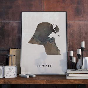 May include: A framed print of a watercolor map of Kuwait. The map is in shades of brown and gray, and the word "KUWAIT" is printed in black at the bottom of the print.