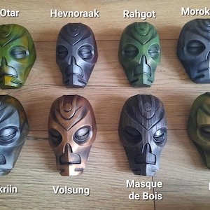 May include: Ten different masks, each with a unique design and color scheme. The masks are made of a hard material and have a variety of textures. The masks are labeled with their names, including Otar, Hevnoraak, Rahgot, Morokei, Nahkriin, Volsung, Masque de Bois, and Krosis.