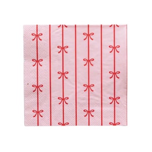 May include: Pink paper napkins with a red bow pattern.