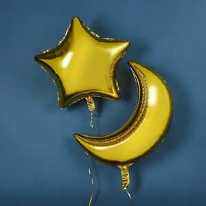 May include: Two gold foil balloons, one shaped like a star and the other shaped like a crescent moon.