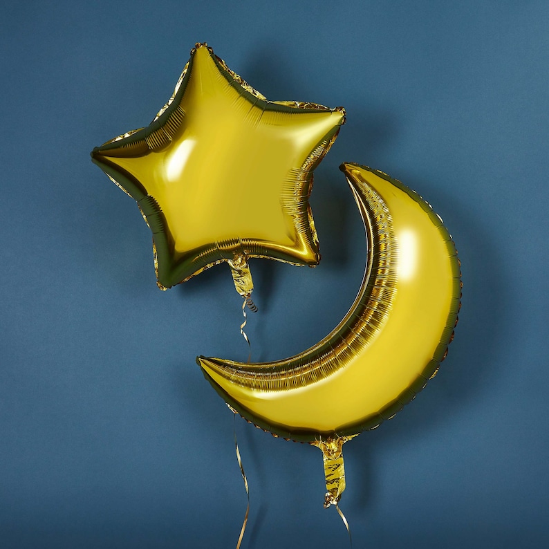 May include: Two gold foil balloons, one shaped like a star and the other shaped like a crescent moon.
