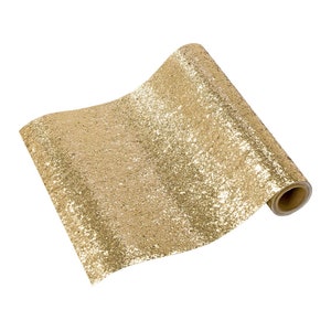 May include: A roll of gold glitter wrapping paper. The paper has a speckled, textured surface.