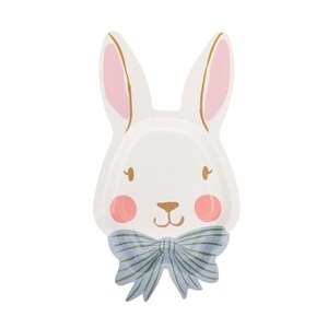 May include: White bunny-shaped paper plate with pink blush cheeks, pink inner ears, and a light blue striped bow tie. The plate has gold accents, ideal for Easter or spring celebrations.