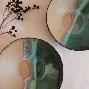 Puede incluir: Dos cuencos de cerámica con un esmalte blanco, marrón y verde. Los cuencos son redondos y tienen un ligero borde.