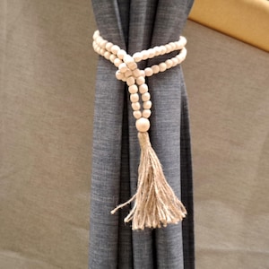 Curtain tie made of natural wooden beads and jute tassel. Stylish and elegant decor for handmade curtains