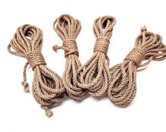 May include: Four spools of natural brown jute rope, each tied in a knot at the end. The rope is thick and textured, and the spools are arranged in a semi-circle.