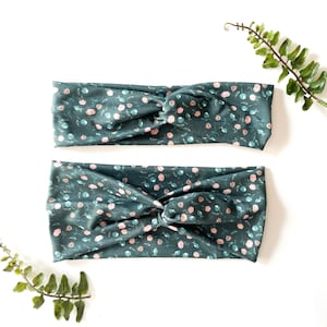 Puede incluir: Dos diademas de color verde oscuro con un estampado floral rosa y azul. Las diademas están hechas de un tejido suave y elástico y son perfectas para añadir un toque de estilo a cualquier atuendo.