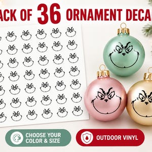 May include: A pack of 36 black vinyl decals featuring a cartoon character face, displayed on a white sheet next to three round Christmas ornaments in mint green, light pink, and gold, each decorated with the same black character face decal.