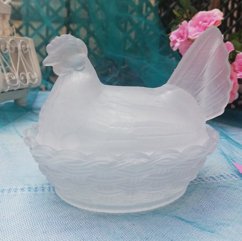 May include: White frosted glass chicken shaped butter dish with a detailed nest design.